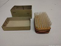 Wood-backed nail brush and cardboard trays