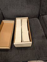 closed two-row storage box filled with cards on sofa