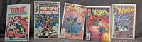 Front covers of all five bagged comic books displayed side by side