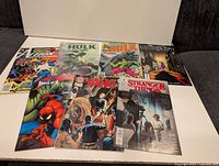All eight comic books laid out front covers visible