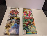 Four comics laid out: three Warlock, one X-Force 35