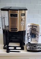 Full view of coffee maker with accessories and manual