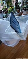 Nested clear bins with blue-green lid inserted