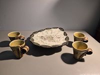Overall view of cake plate with four espresso mugs