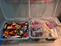 Two clear bins open showing mixed LEGO bricks and bagged parts