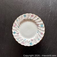 Front view of one luncheon plate showing pattern, scalloped rim and gold trim