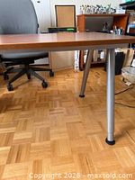 Side view of table showing top and two metal legs