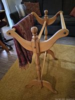 Front angled view of entire quilt rack holding one folded textile