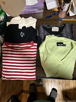 All five folded tops displayed on table