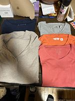 Five folded tops showing colours and styles