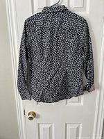 Full back view of navy floral blouse on hanger