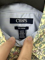 Brand and care label inside collar showing Chaps, size S, fabric content, no-iron, blue pinstripe lining visible