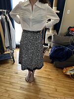 Front view of black and white knee-length A-line skirt worn by model