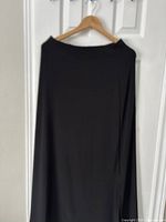 Full view of black ankle-length skirt on hanger