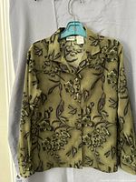 Front view of green Penmans floral blouse on hanger
