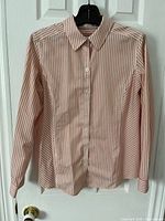 Full front view of blouse on hanger showing overall design, stripes, collar, buttons, long sleeves