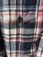 Close-up of chest pocket, plaid pattern and button