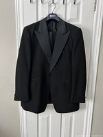 Full view of black tuxedo jacket on hanger