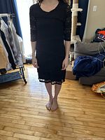 Front view of black lace cocktail dress on model