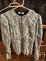 Front view of lace blouse on hanger