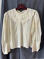 Front view showing lace collar, pintucks, sleeve style