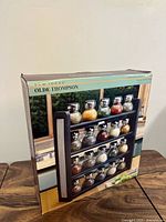 Factory box displaying Olde Thompson 20-jar spice rack set with image of assembled rack and jars