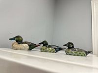 Three painted wooden ducks lined up