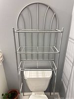 Full view of silver arched metal rack positioned over toilet