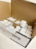 Open box showing multiple white candles in cardboard dividers