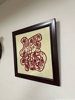 Front view of framed Fu papercut art on wall