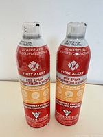 Front view of two sealed First Alert Fire Spray cans