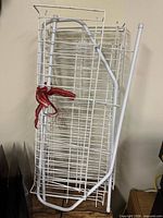 Full view of bundled disassembled white wire rack showing overall form and supports