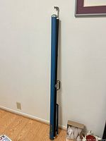 Blue metal Da-Lite screen case standing upright