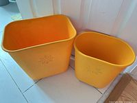 Both orange plastic waste bins side by side