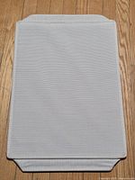 Fabric lid or collapsed bin displayed flat showing texture and color