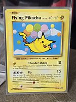 Front of Flying Pikachu card inside protective sleeve
