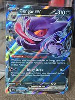 Front of sleeved Gengar ex holo card on stand showing artwork, stats and card number