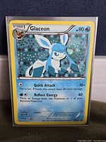 Front of sleeved Glaceon BW90 cosmos holo card showing artwork, foil pattern, and condition