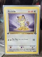 Front of Meowth card in sleeve showing artwork, HP, attack, set number