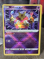 Front of sleeved Radiant Alakazam holographic card in top loader