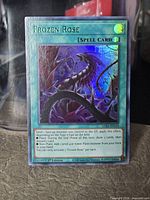 Front of Frozen Rose card showing green foil title, artwork, text box, 1st Edition and set code