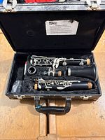 Clarinet disassembled in hard case with mouthpiece and ligature visible