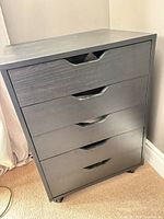 Front view of the five-drawer black chest on casters