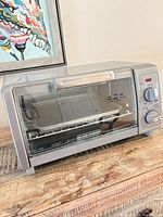 Front view of toaster oven showing brand, controls and glass door