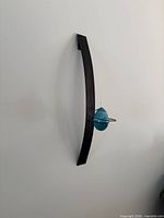 Full view of metal wall sconce with blue egg lamp mounted