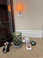 All items: corded green glass tabletop warmer with cord, two plug-in wall warmers, wax melts