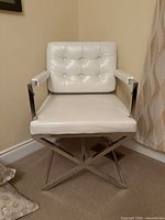 Front view of white faux leather armchair with chrome X-base frame