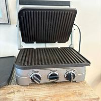 Open Cuisinart contact grill showing ridged cooking plates and control panel