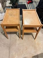 Pair of light brown veneer end tables side by side showing full structure
