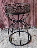 Full view of black metal side table on rug
